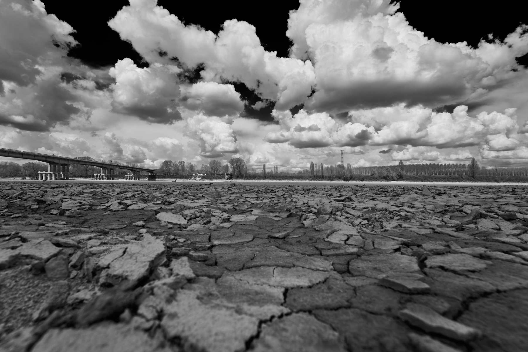 Terra crepata sotto un cielo di nuvole, presso il ponte di Boretto