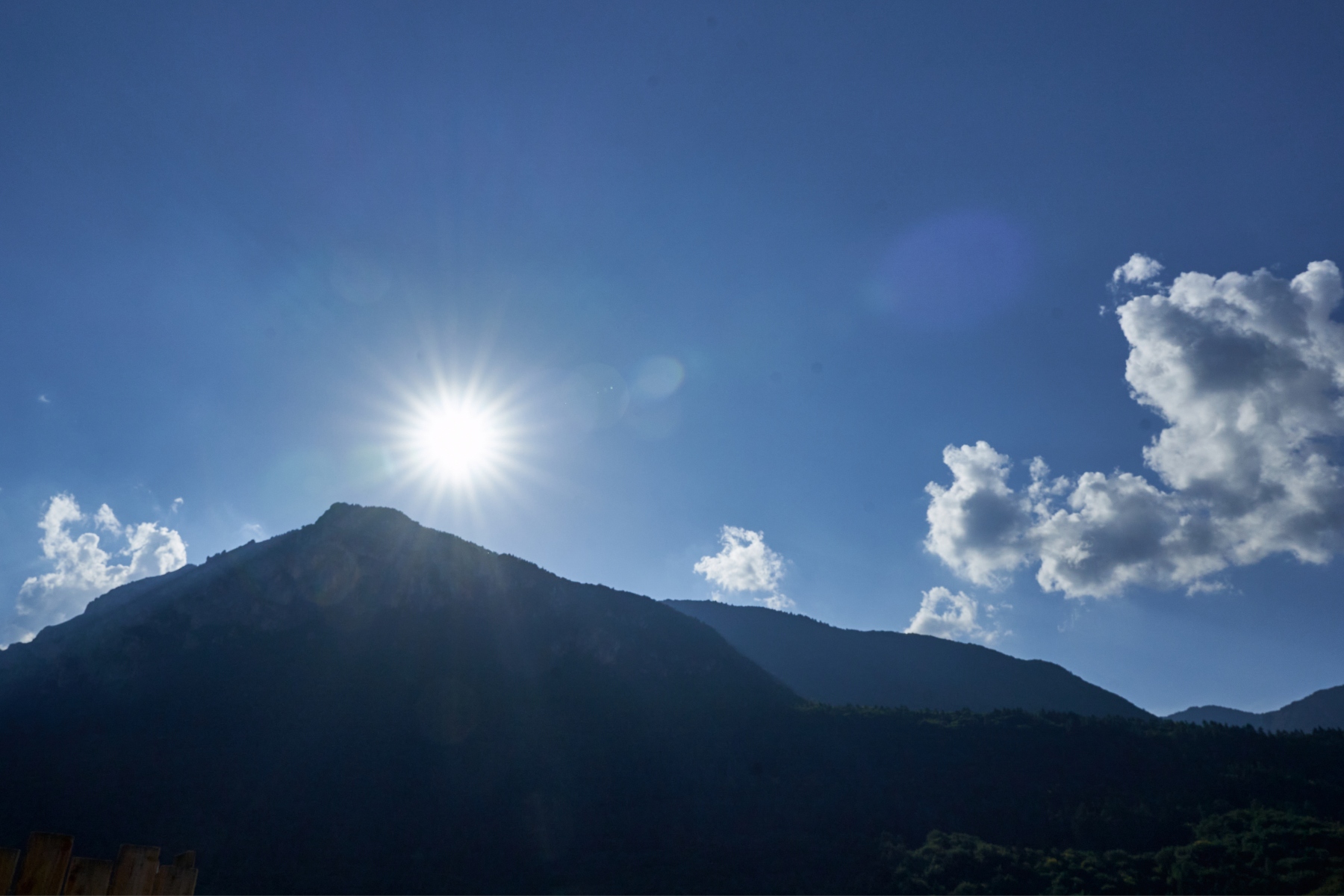 Il sole a stella sopra le montagne in controluce
