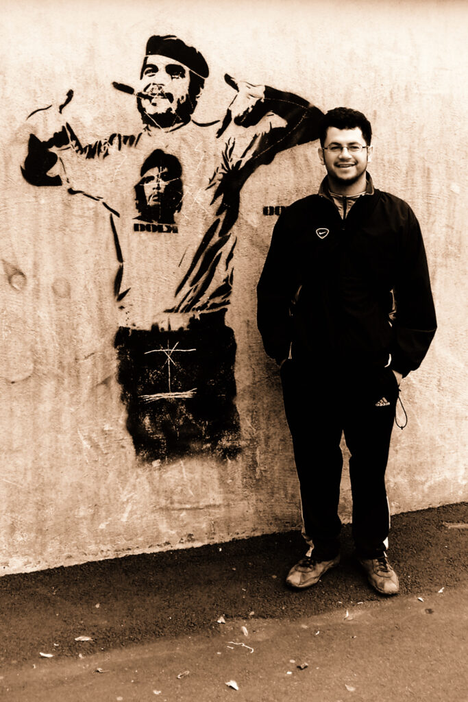 Francesco accanto a un murale, fotografia color seppia