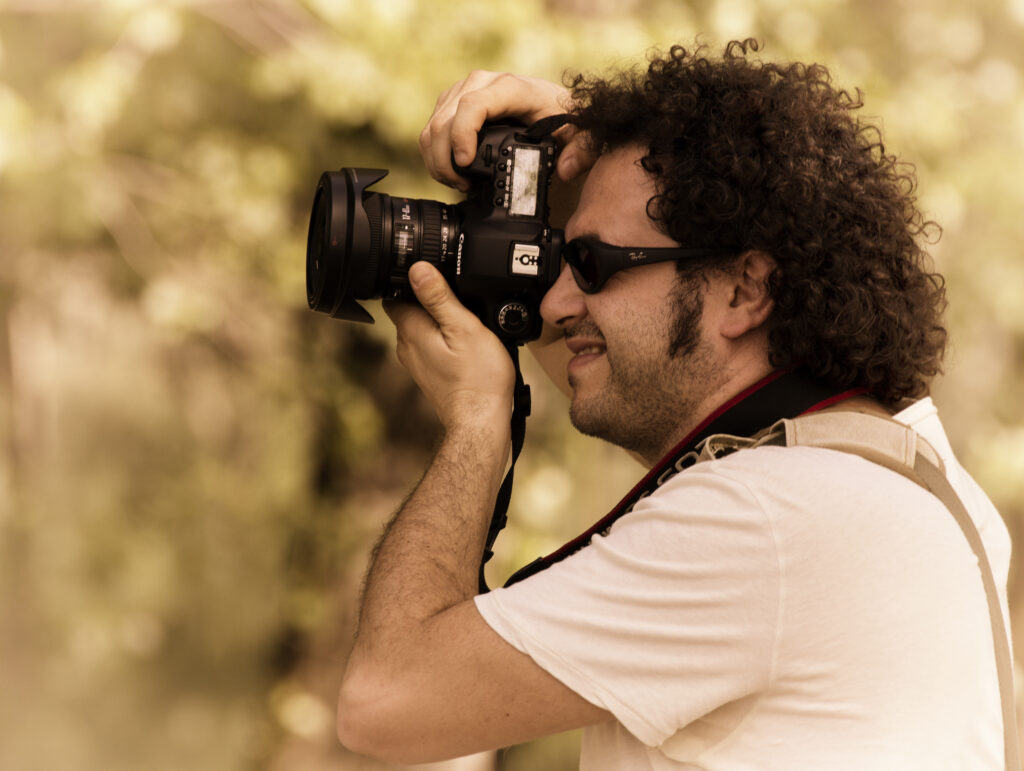 Francesco di profilo mentre scatta una fotografia