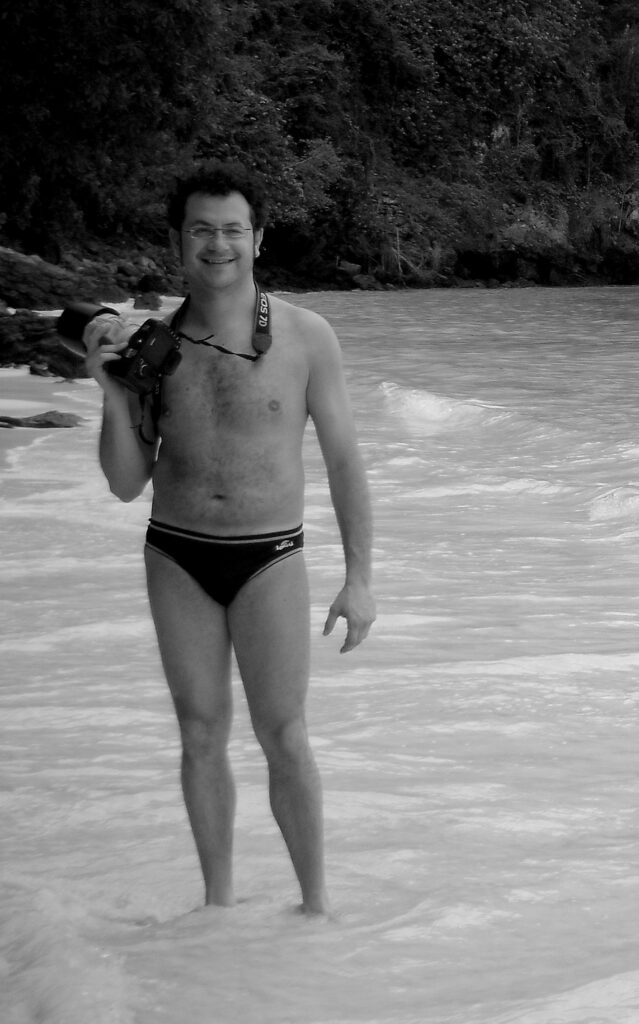 Francesco in riva al mare con la macchina fotografica, in bianco e nero