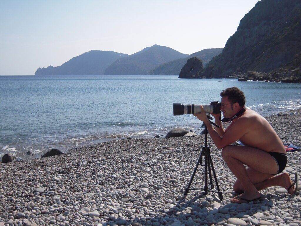 Francesco fotografa dalla spiaggia con un teleobiettivo su treppiede